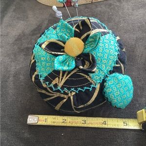 Hand-made large pin cushion with three decorative pins and emery sharpening pad.